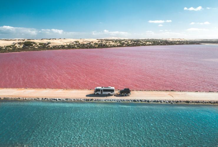 南オーストラリア州、エア半島のマクドネル湖とグリーン湖を結ぶ未舗装の道路を、小型車を牽引しながら走り抜けるバン © Jaxon Foale