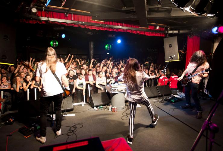 維多利亞州里奇蒙Corner Hotel內樂隊在台上表演，台下的人群在空中揮手©Zo Damage
