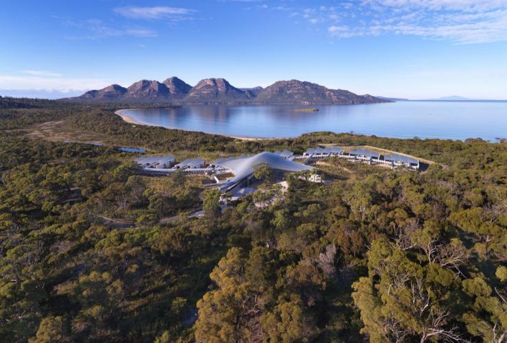 從空中俯瞰塔斯曼尼亞Saffire Freycinet隱藏在樹林中的住宿，背景是歌斯灣和菲欣納國家公園©Saffire Freycinet