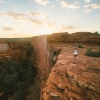  一名女子於日出時在帝王谷（Kings Canyon）頂端漫步©北領地旅遊局/Mitchell Cox（2017年）